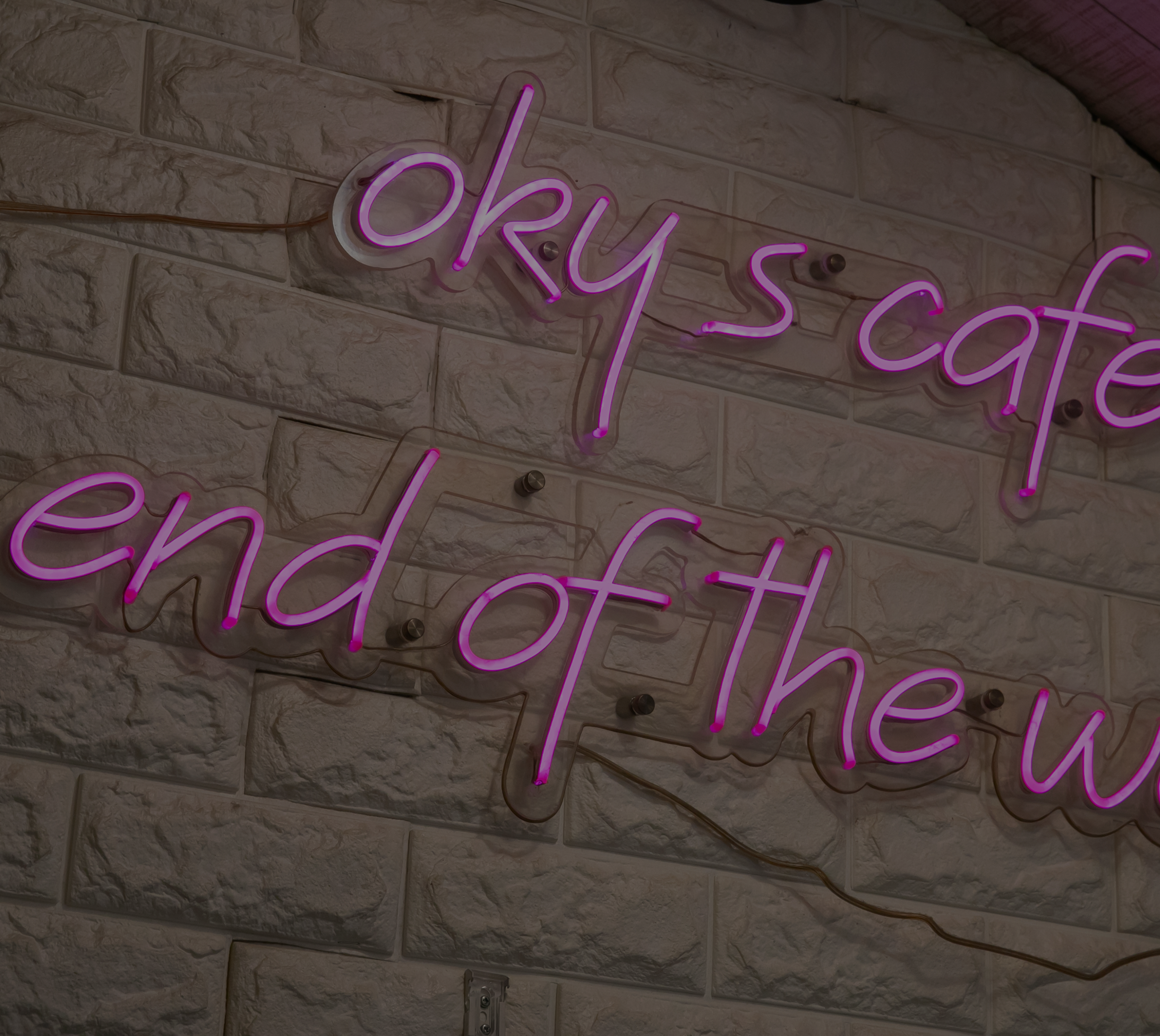レンガ壁に灯る oky's cafe のネオンサイン